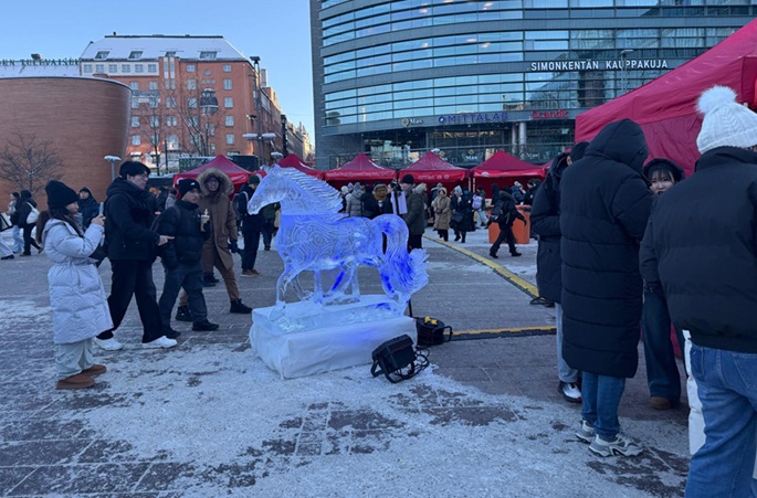 Photo with a Year of the Horse-themed ice sculpture at the 2026 Happy Chinese New Year folk fair in Helsinki on Friday. DF Photo