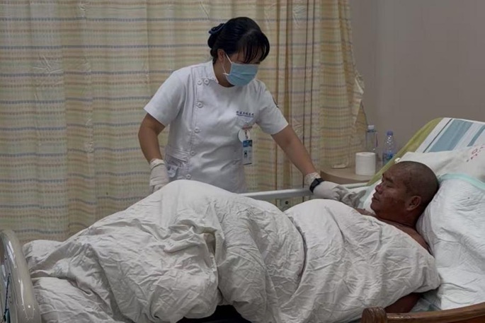 A medical worker takes care of Qin Jianping at Chengmai County People's Hospital in Chengmai County, south China's Hainan Province, June 6, 2026. Photo: Xinhua by Wu Maohui.