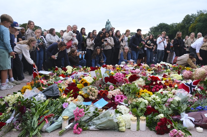 People mourn King Harald V beside flowers, candles and Norwegian flags laid outside the Royal Palace in Oslo, Norway, on Aug. 28, 2026. Photo: Xinhua by Zhang Yuliang.